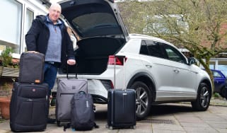 Kim Adams standing with luggage behind Volkswagen T-Roc